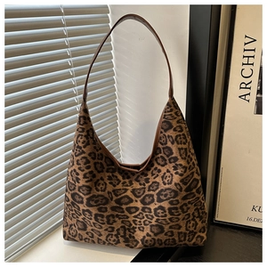Detail of hobo leopard print shoulder bag displayed on a windowsill with warm natural light