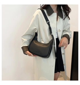 Detail showing black crescent moon leather bag with adjustable strap and fashion bag logo