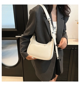 Detail of cream hobo bag with New York print and adjustable silver buckle strap