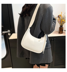 Detail of white hobo bag showing textured leather finish and New York print detail