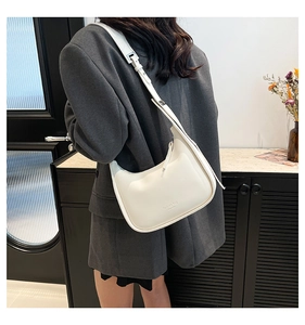 Detail of white crescent moon shoulder bag with fashion bag NEW YORK text and metal buckle