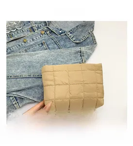 Detailopname van de kaki gewatteerde dons-clutch met grote ruiten en een zachte textuur