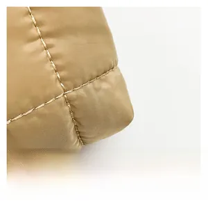Macro-opname van goudbruine gewatteerde nylon stof met geplooide stiksels details