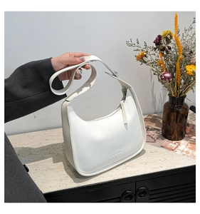 Detailed macro view of white crescent shoulder bag featuring premium smooth leather and zipper