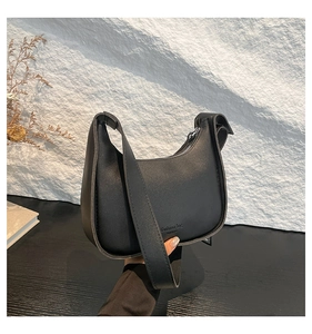 Detail of minimalist black crescent bag with matte finish and fashion logo print