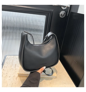 Close-up of black crescent shoulder bag with fashion bag text and silver zipper detail
