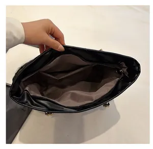 Interior layout of large black tote bag showing brown fabric lining and zip pockets