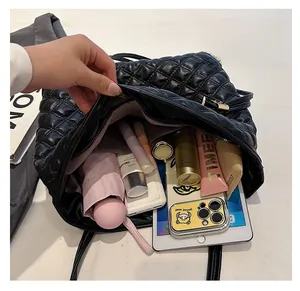Interior view of large black quilted tote bag showing spacious storage for a tablet and cosmetics