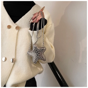 Detail of silver star-shaped clutch bag with sparkling rhinestones and metal snake chain