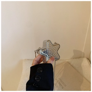 Gros plan d'un mini sac argenté en forme d'étoile avec strass brillants et bandoulière