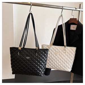Quilted leather tote bags in black and white hanging on display for a minimalist fashion look