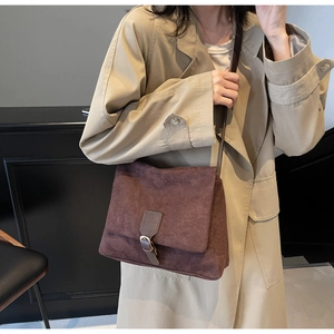 Detail of dark brown suede vintage crossbody bag shown with a khaki trench coat for commute