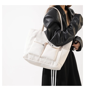 Detailansicht der weißen Canvas-Tasche mit Utility-Taschen für den täglichen Arbeitsweg