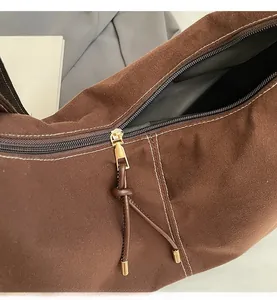 Gros plan d'une fermeture éclair dorée avec tirette en cuir marron sur le sac