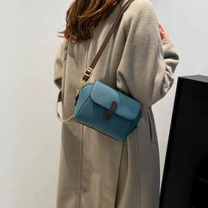 Sac à bandoulière bleu en cuir grainé pour femme avec sangle marron et boucles