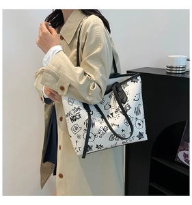 Détail d'un grand sac cabas blanc avec imprimés graffiti noirs et fines bandoulières