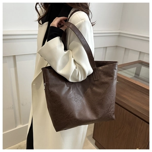 Detail view of large dark brown retro tote bag with side zipper pocket and oil wax texture