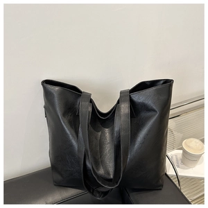Vista macro del bolso tote grande de cuero PU negro con correas planas y textura natural
