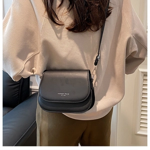 Détail du sac de selle en cuir noir avec logo tendance et boucle en métal argenté