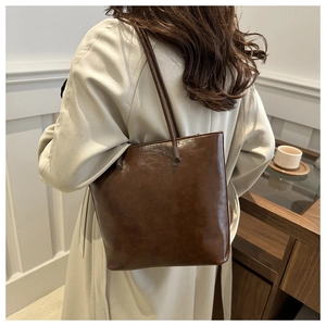 Close-up of dark brown glossy leather tote bag with elegant texture and vintage style
