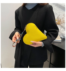 Detail of heart-shaped yellow coin purse with pebbled leather and LOVE wristlet strap