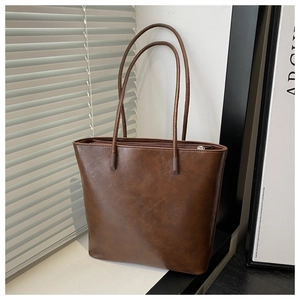 Detail of dark brown vintage faux leather tote bag with elegant shadow texture