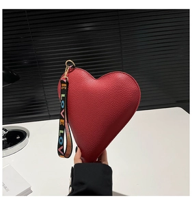 Detail of red heart-shaped purse in lychee grain leather with colorful LOVE wristlet