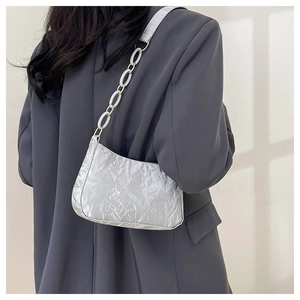 Silver crescent shoulder bag with metallic wrinkled texture and white chain strap detail