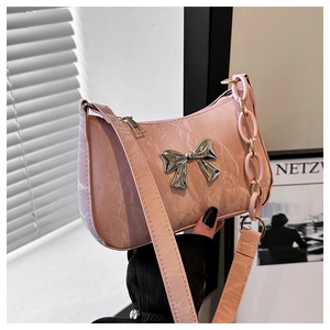 Detailed macro view of pink crescent bag with metallic silver bow and pleated texture