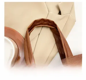 Detail view of the wide, comfortable brown leather shoulder strap with neat stitching