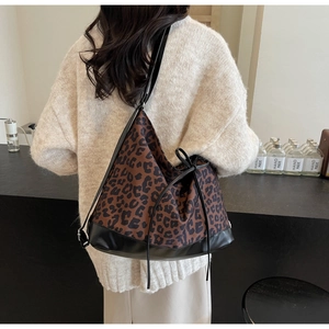Lifestyle shot of large leopard print tote bag with black leather bottom and drawstring