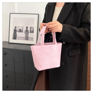Detail shot of mini pink tote bag featuring unique pleated leather texture and dual handles