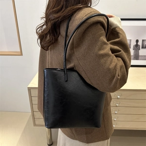 Minimalist black leather tote bag for women showing a spacious and retro commute style