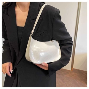 Detailed view of the pearly white baguette bag texture with smooth zipper and stitching