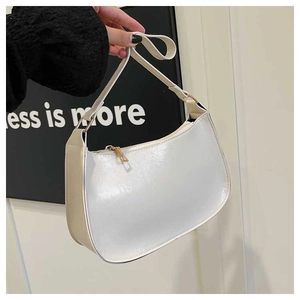 Detailed macro view of white crescent bag with glossy crinkle texture and gold hardware