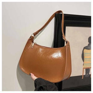 Detailed view of the glossy brown crescent shoulder bag with golden zipper and oil wax texture