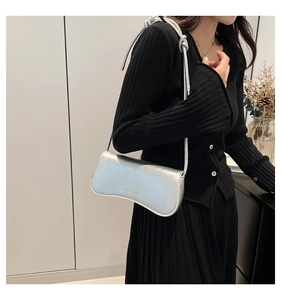 Silver underarm bag with metallic pleated texture and Fashion & Bags yellow lettering