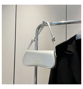 Detail of silver faux leather underarm bag with knot strap and metallic finish