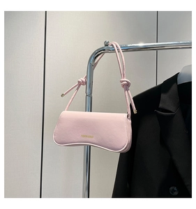 Pink underarm bag detail with unique cracked texture faux leather and knotted strap design