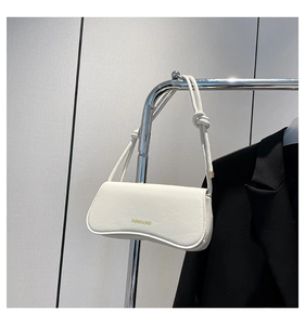 Detailed view of a white leather underarm bag featuring Fashion & Bags logo print