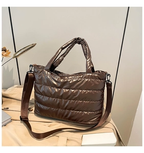 Close-up of coffee brown quilted tote bag showing padded texture and nylon strap