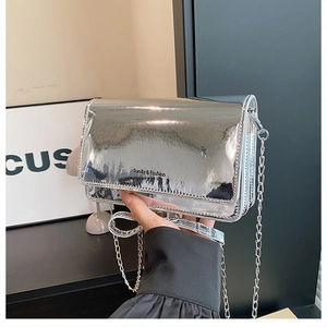 Detail of silver mirror finish small square bag with metal chain strap and logo