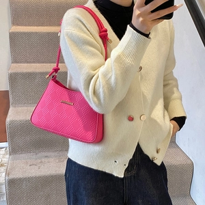 Hot pink checkerboard shoulder bag with stylish knotted strap and gold hardware shown on model