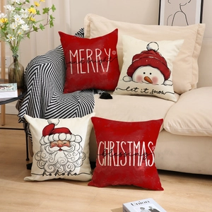 Set of four Christmas throw pillow covers with Santa and Snowman on a cozy beige sofa