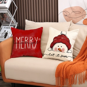 Christmas throw pillows with Merry and Let It Snow text on a cozy beige sofa