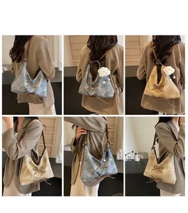 Viste dettagliate dello zaino tote in denim vintage con cinturini in pelle e ciondolo