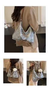 Dettaglio della borsa tote in denim con cinturini in pelle e ciondolo a nuvola