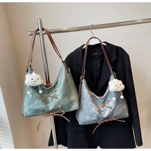 Dettaglio della borsa vintage con fiocco in pelle e ciondolo a nuvola di peluche