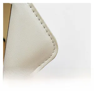 Close-up of white quilted leather bag showing fine pebble texture and gold metal detail