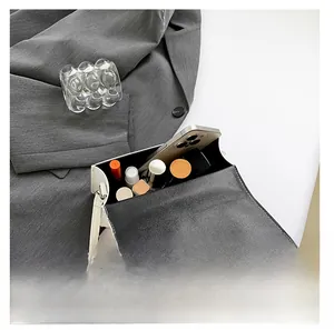 Interior view of white crossbody bag showing storage for phone and lipstick cosmetics